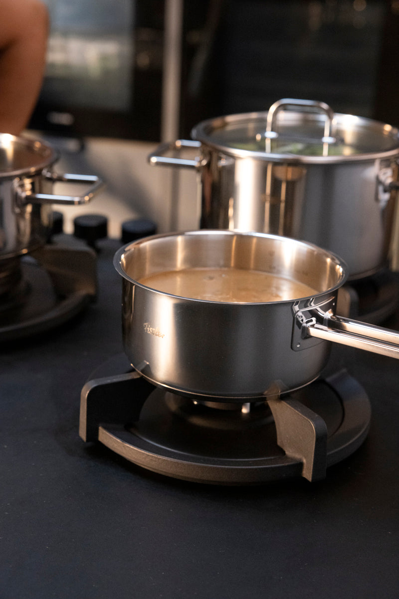 Fissler Viseo® Pro 16 cm saucepan heats on an electric stove, timeless design with other Fissler pots in view.