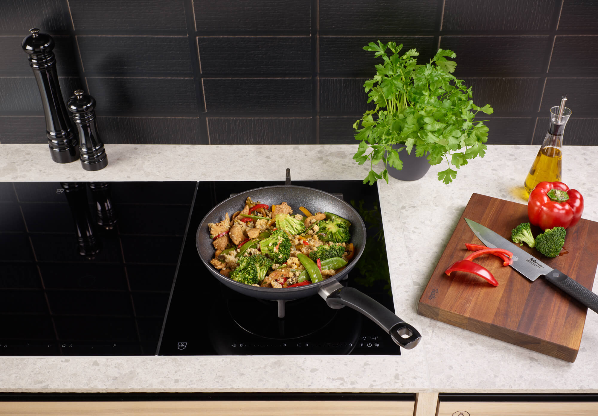 Fissler Adamant® Classic Frying Pan Set in use on the stove with stir-fry and fresh ingredients - precision and durability "Made in Germany".