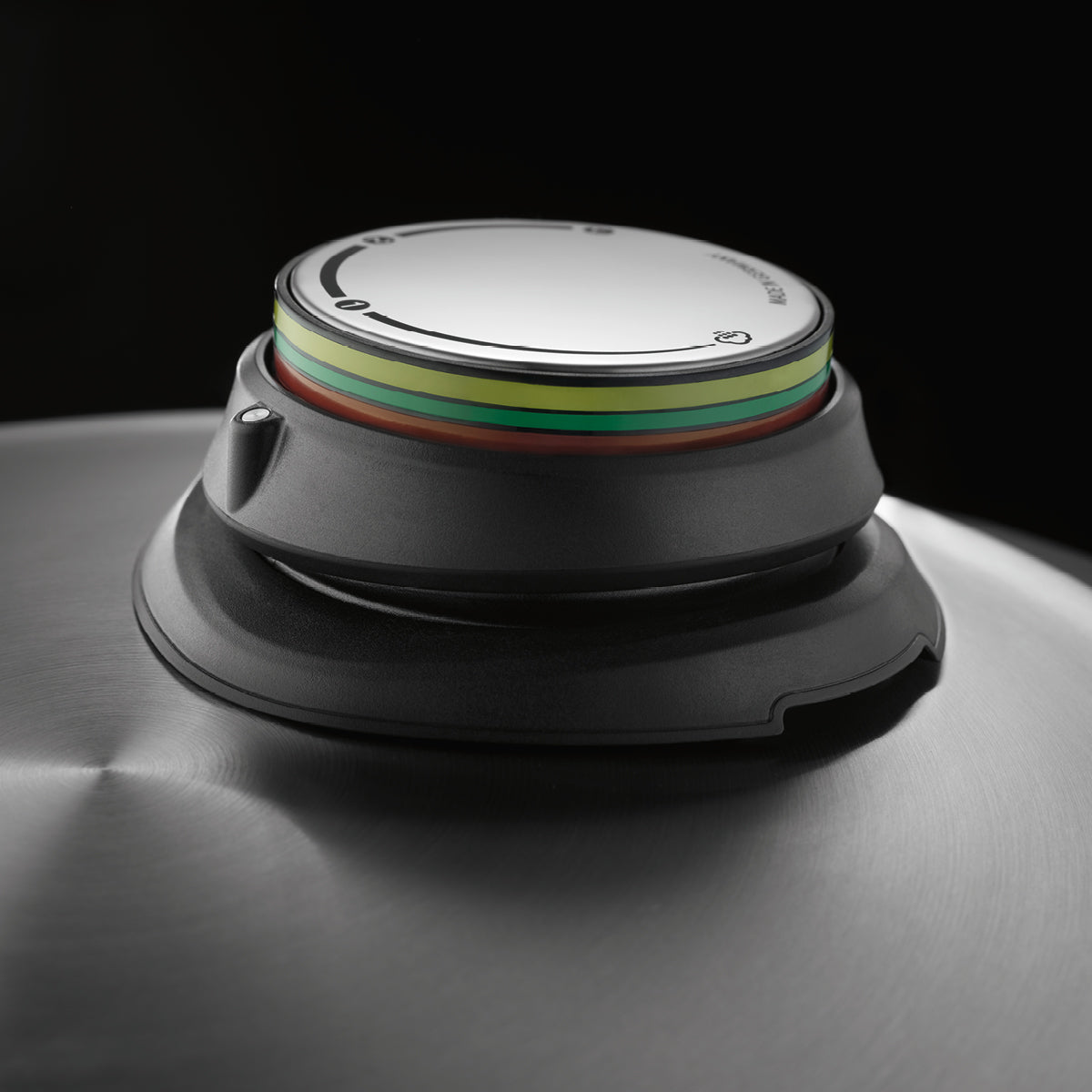 Nahaufnahme des Fissler-Edelstahl-Topfdeckels mit Präzisionsdruckanzeige, grün-gelb-rotes Manometer, das die deutsche Ingenieurskunst hervorhebt.