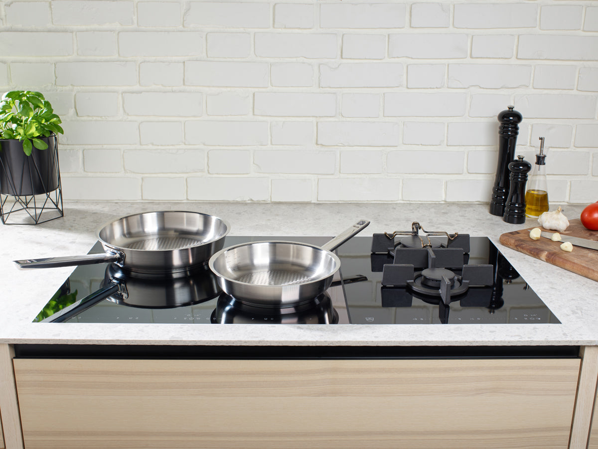 Two Fissler Original-Profi Collection® saucepans on an induction hob, highlighting German precision quality in a modern kitchen.