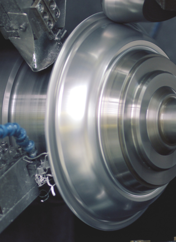 Eine Nahaufnahme von Präzisionsmetallarbeiten, die rostfreien Stahl formen und die deutsche Ingenieurs- und Handwerkskunst von Fissler widerspiegeln.
