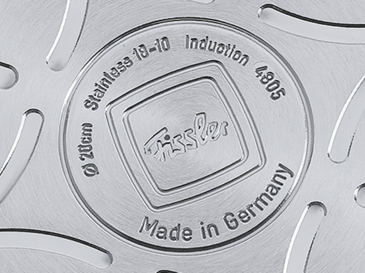 Detail of a Fissler pan base made of high-quality stainless steel, with engraving: brand, size, suitable for induction, Made in Germany.