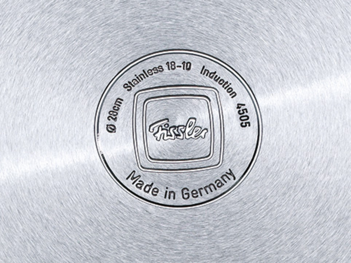 Detailed close-up of the precisely embossed brushed stainless steel base from Fissler, proudly Made in Germany - durable and timeless.