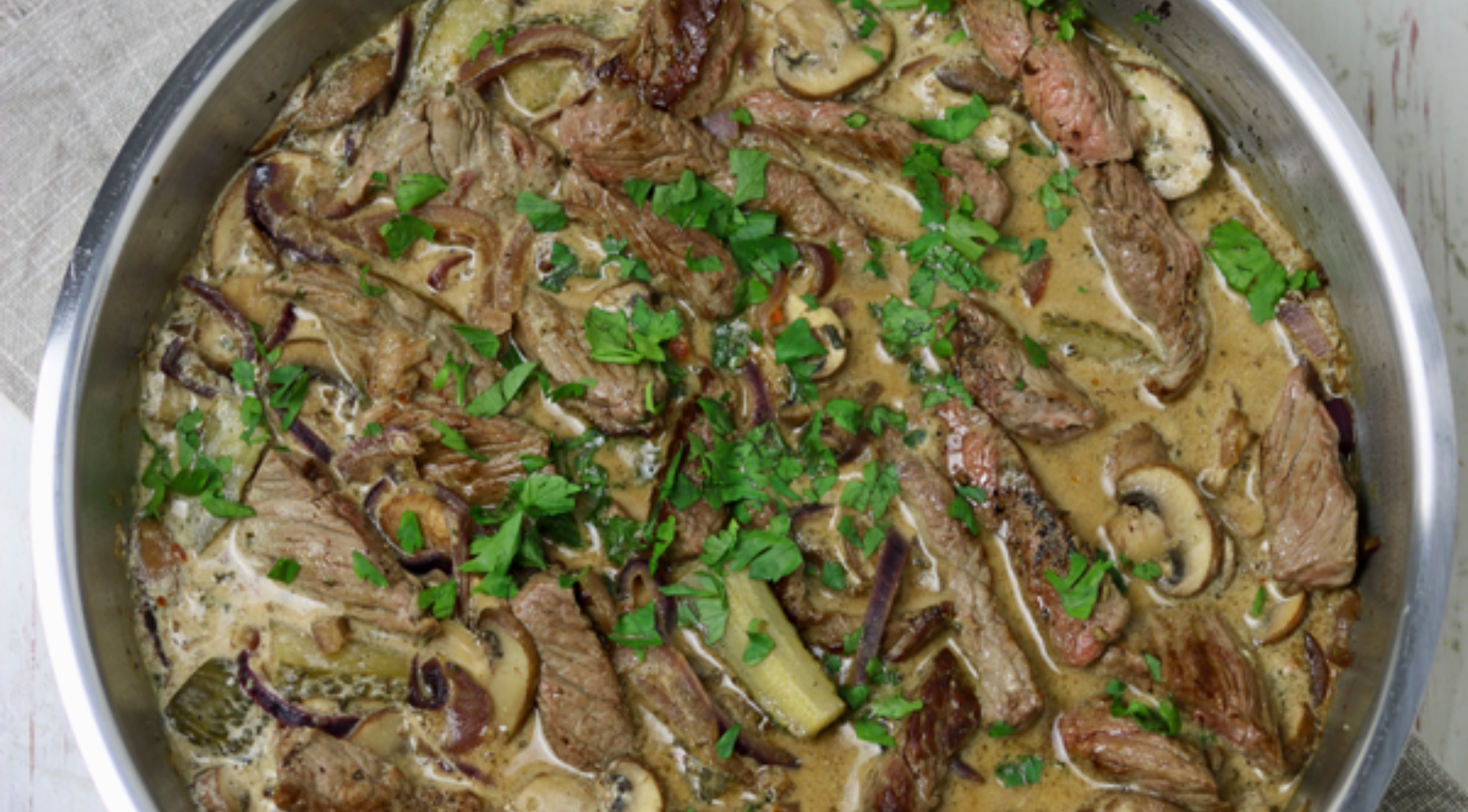 Rinderstroganoff mit Rindfleischstreifen, Champignons und Zwiebeln in einer reichhaltigen Soße, serviert in einer Fissler-Pfanne - Präzisionsarbeit aus Deutschland.