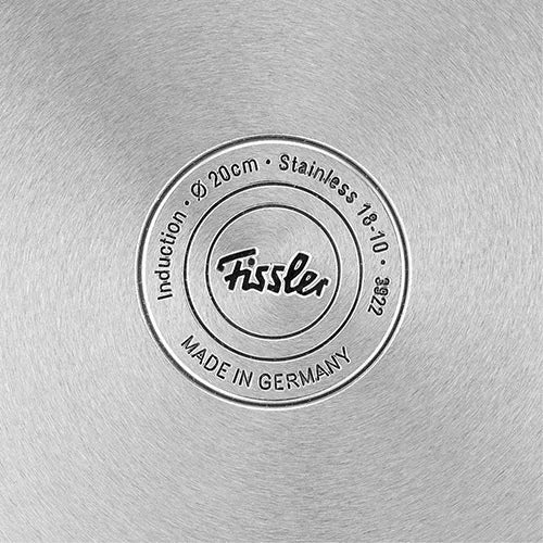 Fisslers charakteristischer Edelstahlsockel, Ø 20 cm, mit Präzisionslogostempel und "MADE IN GERMANY" in konzentrischem, gebürstetem Stahl.
