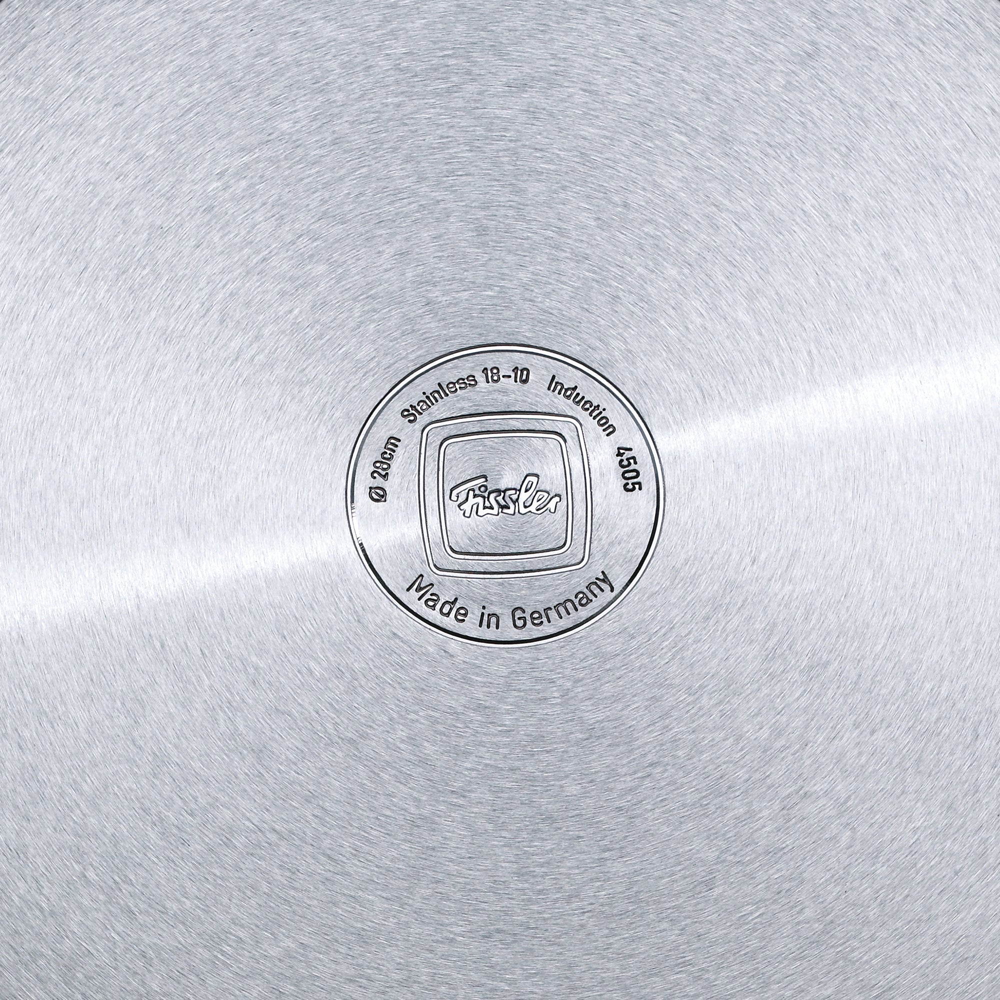 Nahaufnahme des Fissler Pfannenbodens mit eingraviertem Logo, Edelstahl 18-10, Ø 28cm, induktionsgeeignet. Deutsche Präzision seit 1845.