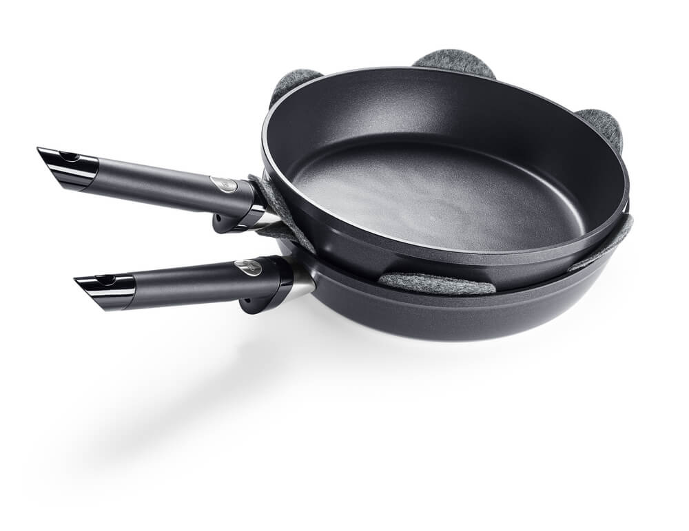 Zwei hochwertige Fissler Pfannen mit Antihaftbeschichtung, die mit dem Fissler Pfannenschutz gestapelt sind und deutsche Qualität und innovativen Schutz bieten.