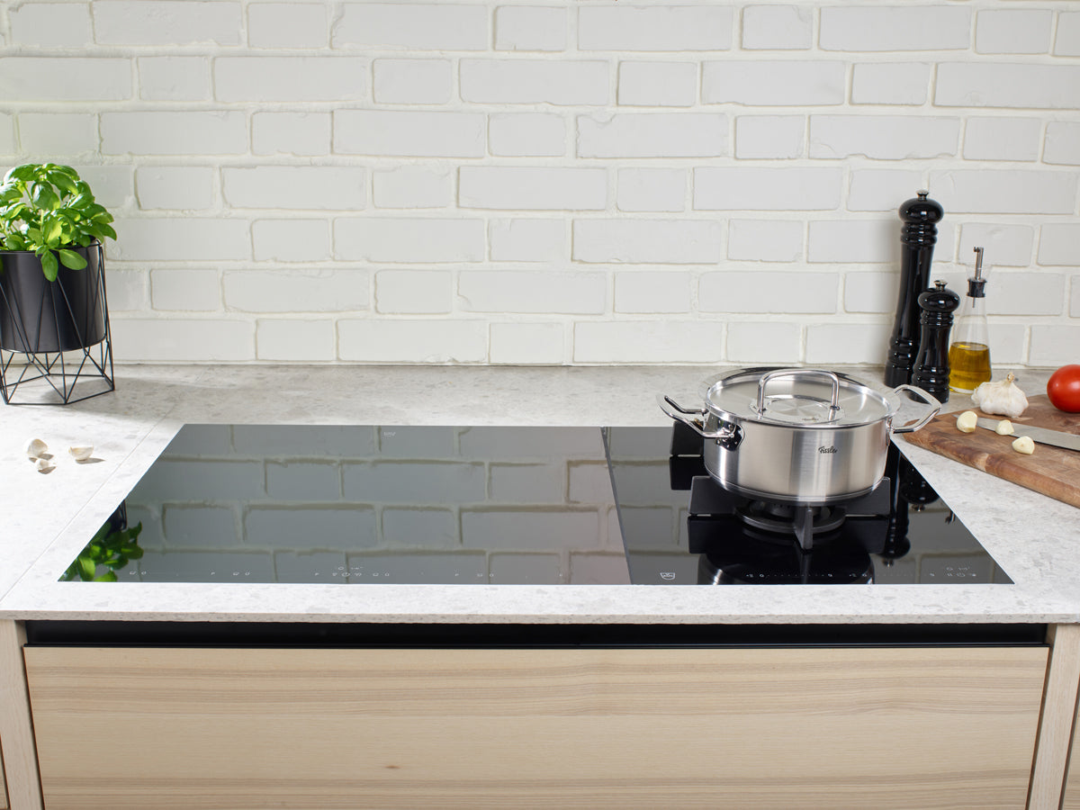 In a modern kitchen, the 3-piece Cookware Set from the Fissler Original-Profi Collection® sits on an induction hob, embodying German quality.