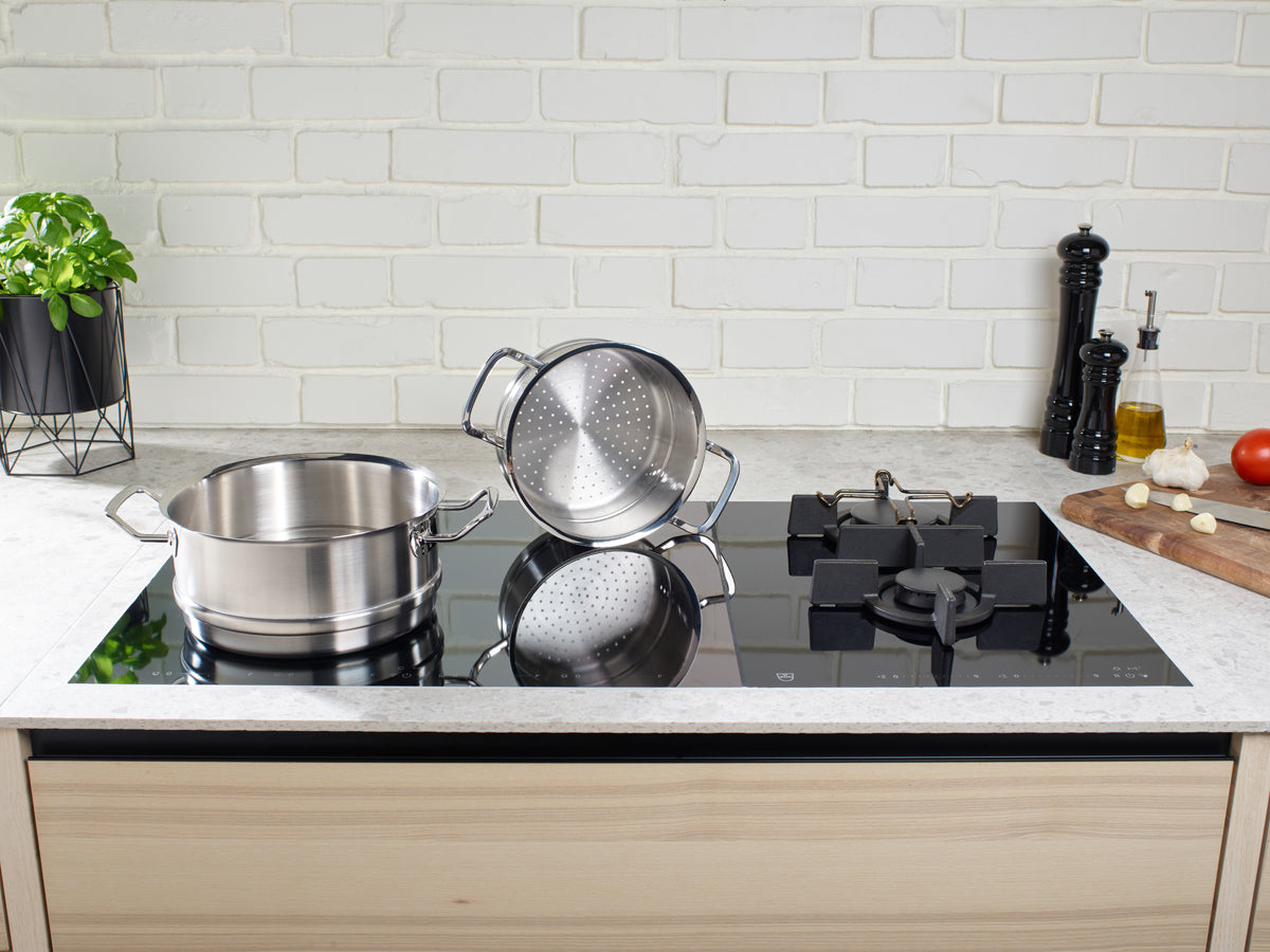 Fissler Original-Profi Collection® Topf-Set mit Glasdeckeln und Dämpfeinsatz auf dem Herd, frische Zutaten, spülmaschinengeeignet.