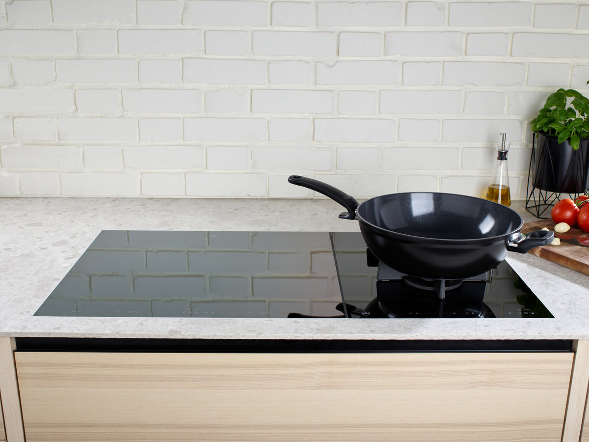 Eine moderne Küche unterstreicht der Fissler Ceratal® PTFE-freie Wok Orbitschwarz mit frischen Zutaten und deutschem Präzisionsdesign.