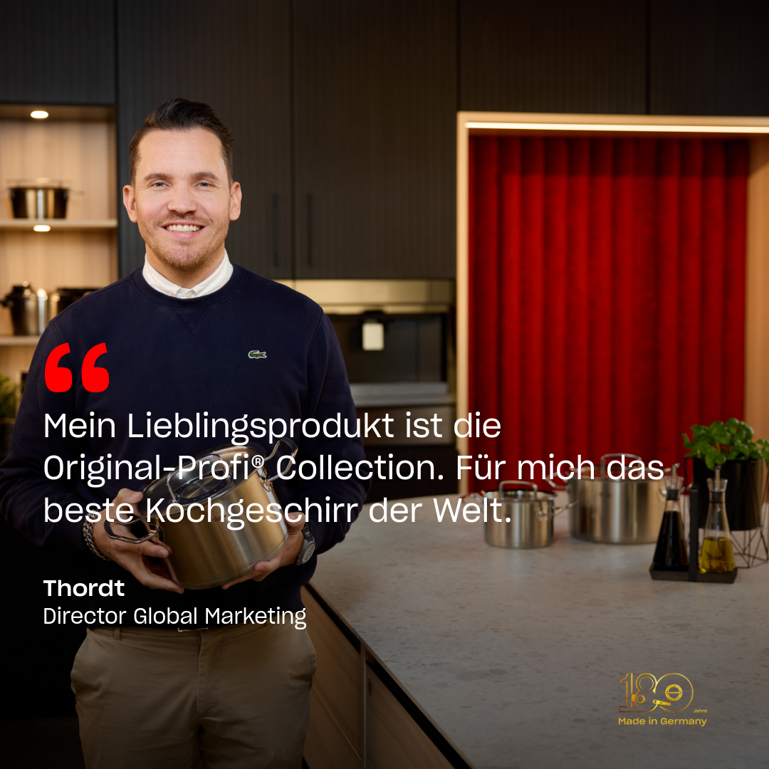 Thordt, Director Global Marketing bei Fissler, lächelt in einer modernen Küche und hält einen hochwertigen Edelstahltopf in der Hand; hinter ihm ein Regal.