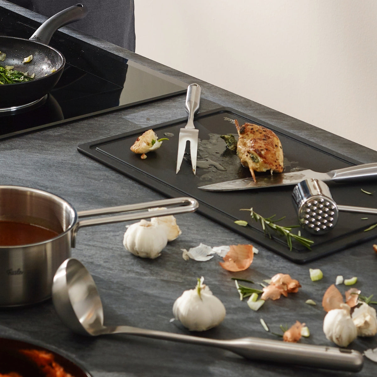 Moderne Küche mit Fissler Essential® Schöpflöffel, Kochtopf, Edelstahlpfannen und Küchenhelfer - Präzision trifft auf zeitloses Design.