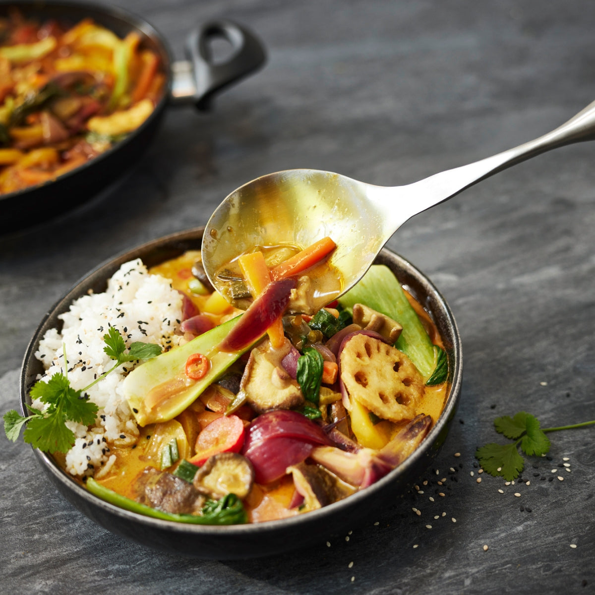 Kräftiges Gemüsecurry mit Reis, serviert mit einem Fissler Essential® Gemüse-/Reislöffel - Präzision, Qualität und zeitloses Design.