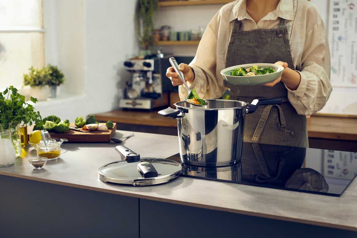 Food is served from the Fissler Vitaquick® Elemental Pressure Cooker Set in a modern kitchen; fresh produce is on the counter.