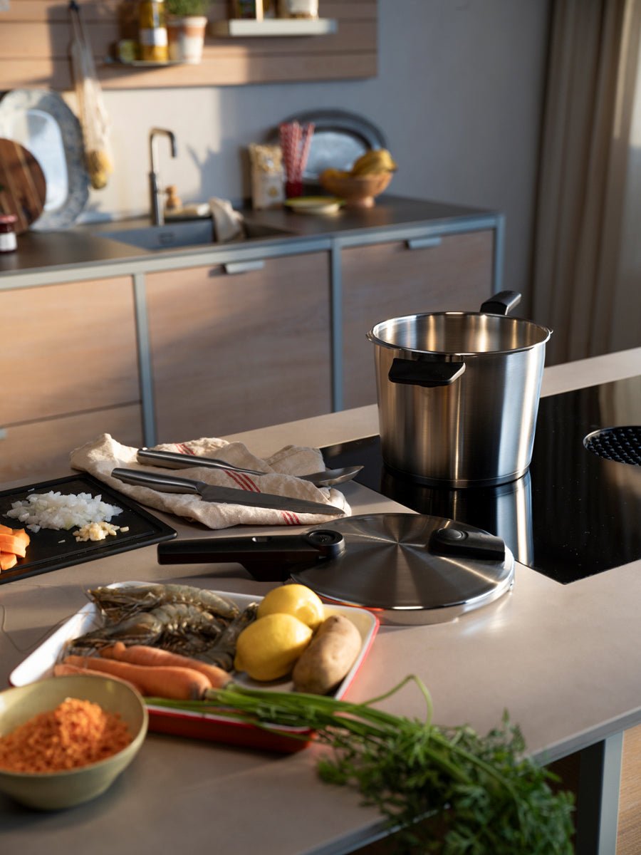 In a modern kitchen, the Fissler Vitaquick® Premium 2-pc. Pressure Cooker Set sits among fresh ingredients, ready for fast, healthy cooking.