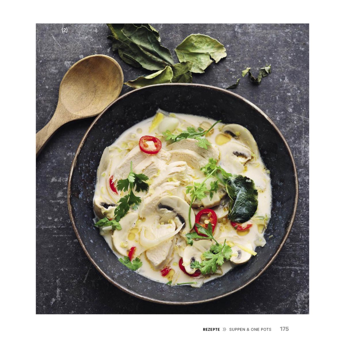 Cremige Hühnersuppe mit Champignons, Chili und Kräutern auf einem dunklen Teller - effizient zubereitet mit einem Fissler Schnellkochtopf.