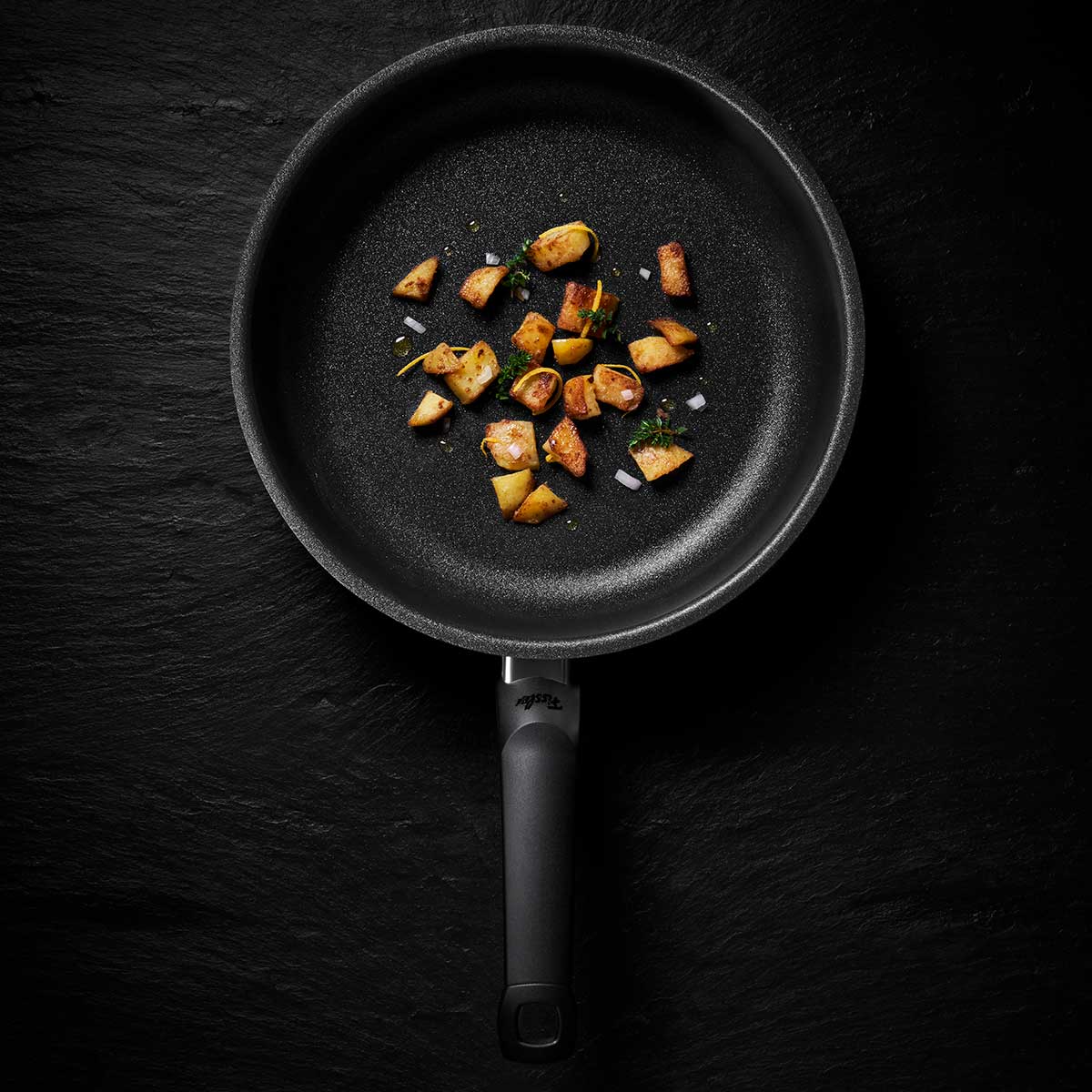 Fissler Adamant® Premium Pfanne mit Bratkartoffeln, die sich durch deutsche Antihaftqualität und zeitloses, langlebiges Design auszeichnet.