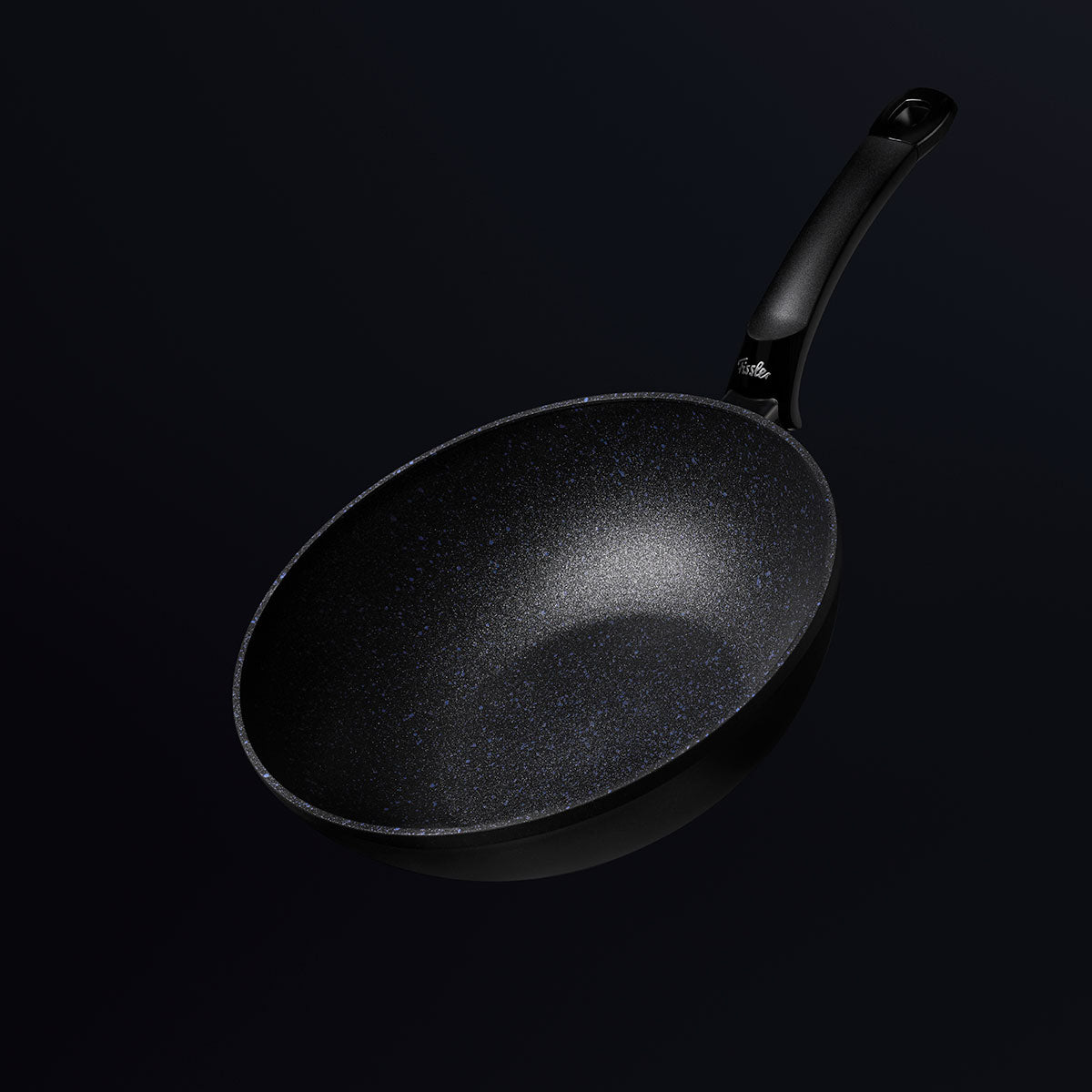 Die Fissler Adamant® Wokpfanne mit ihrer kratzfesten Antihaftbeschichtung und dem schlanken Griff hebt sich von einem dunklen Hintergrund ab.