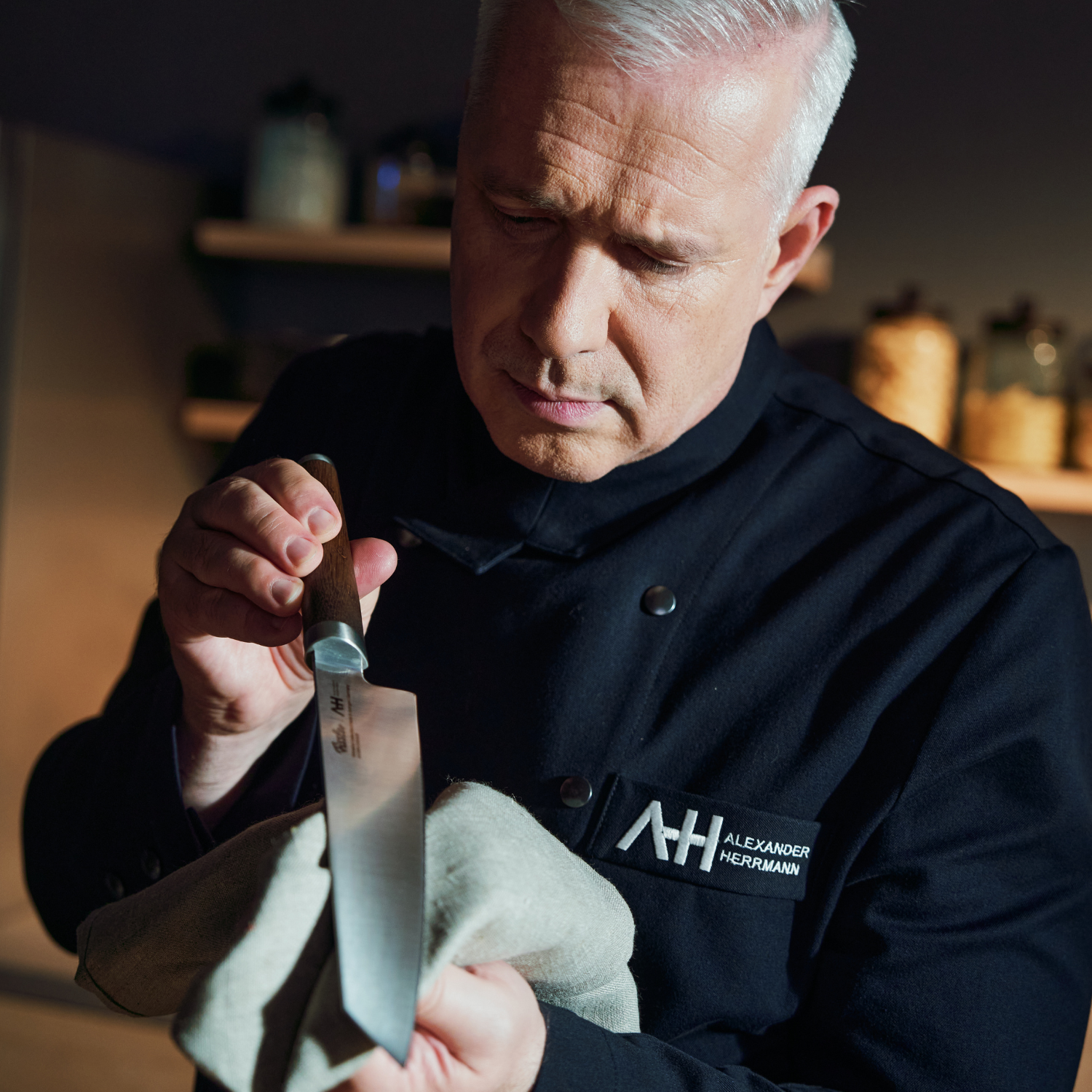 Chef Alexander Herrmann polishes a high-quality Fissler kitchen knife, showcasing German precision and quality in a modern kitchen setting.