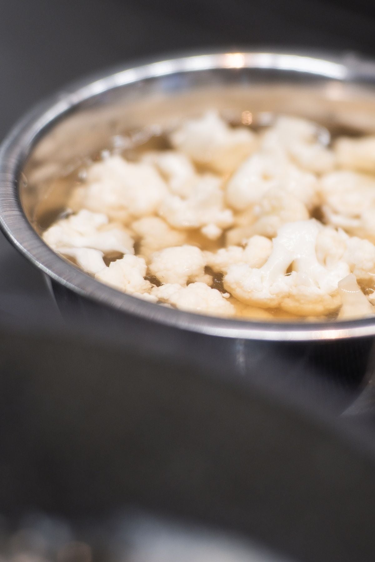 The cauliflower florets swell in a high-quality Fissler stainless steel bowl, showcasing German engineering quality.