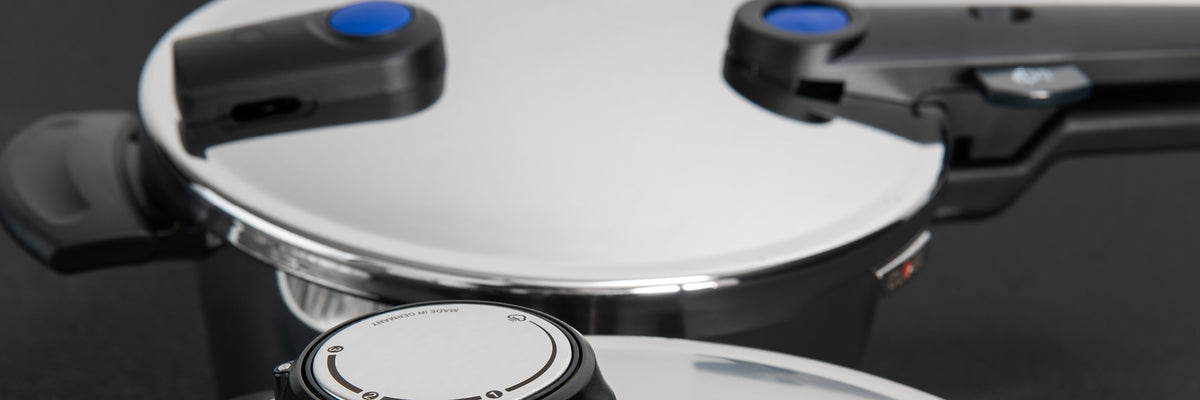 Zwei Fissler Schnellkochtöpfe aus Edelstahl mit schwarzen Griffen und blauen Anzeigen, die für deutsche Präzision und zeitloses Design stehen.