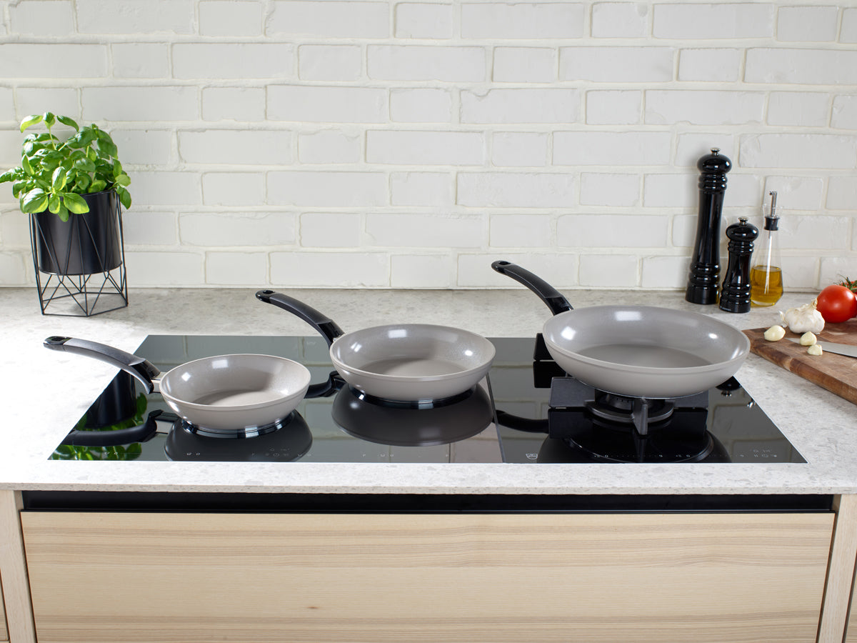 Fissler Ceratal® Classic pans with PTFE-free ceramic coating on the induction hob, showcasing German precision and design.