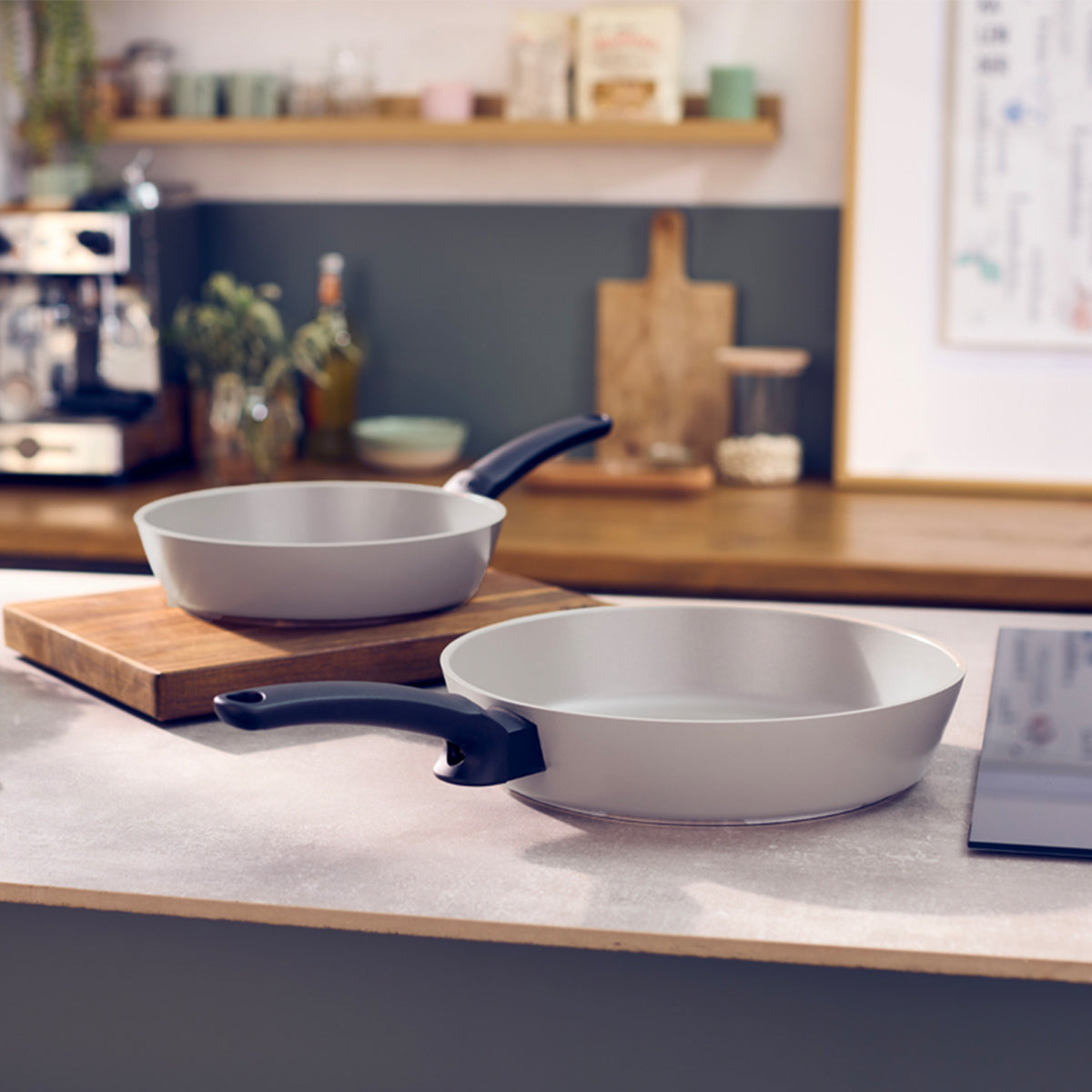 Fissler Ceratal® Evo Comfort pans (24 cm & 28 cm) with black handles display German precision and durability on a kitchen counter.