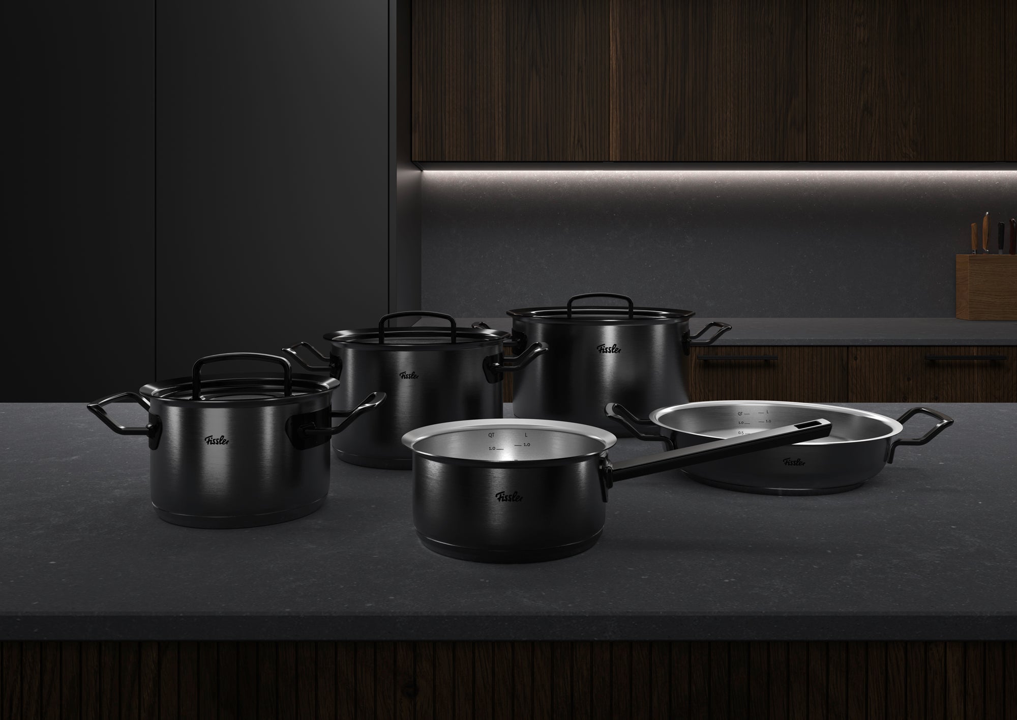5-piece Fissler Original-Profi Collection® Shadowline set made of stainless steel, made in Germany, on an elegant counter with wood accents.