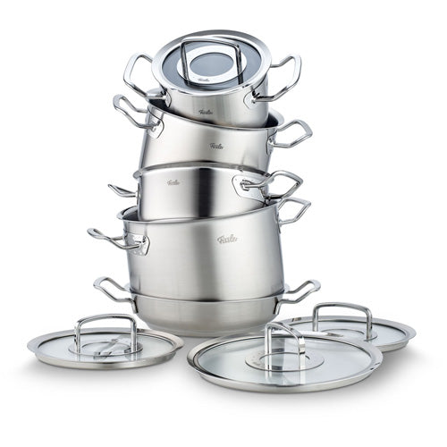 Fissler Edelstahltöpfe, präzisionsgefertigt in Deutschland, gestapelt mit vorgesetzten Deckeln, stabilen Griffen und polierter Oberfläche.