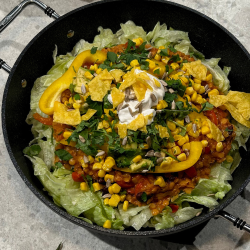 Ein Taco-Salat, serviert in einer eleganten schwarzen Schale, mit frischen Zutaten - perfekt präsentiert mit Fisslers Präzision und Stil.
