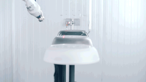 Ein Roboterarm versieht Edelstahl-Kochgeschirr in einer makellosen, modernen Fabrik mit einem makellosen Finish, das die Präzisionstechnik von Fissler zeigt.
