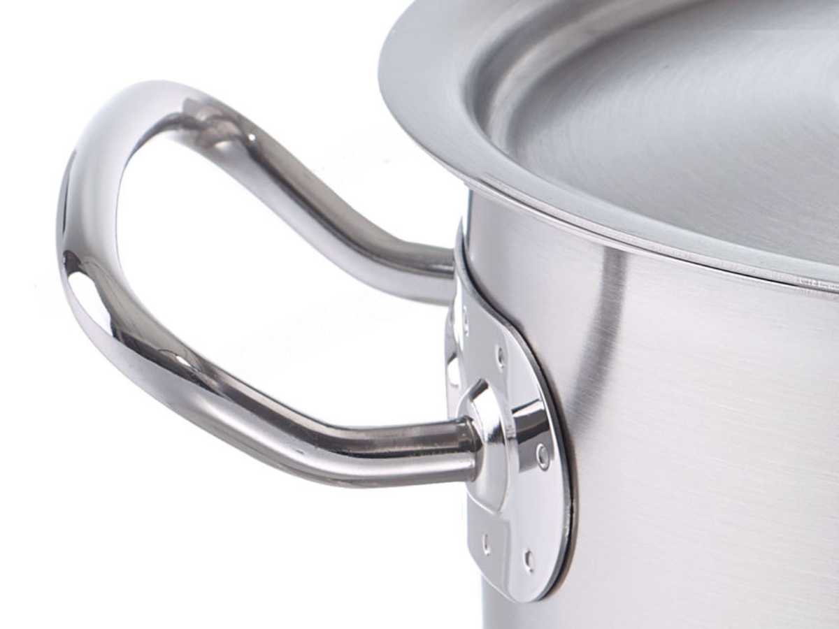 Close-up of a Fissler stainless steel pot with lid, featuring a precision-engineered handle that embodies durability and timeless German design.