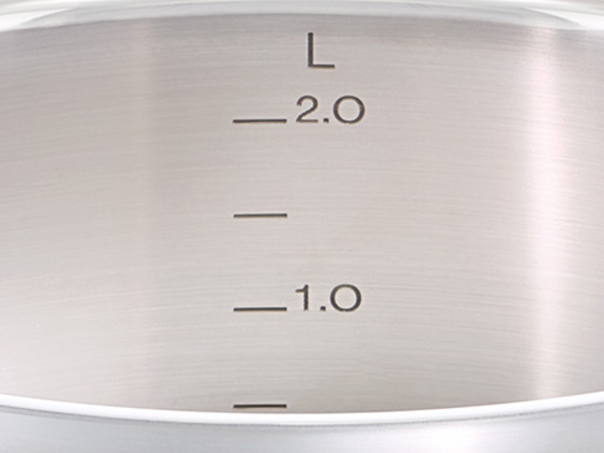 Close-up of the inside of a Fissler stainless steel pot with precise, laser-engraved liter markings at 1.0 and 2.0 for accuracy.