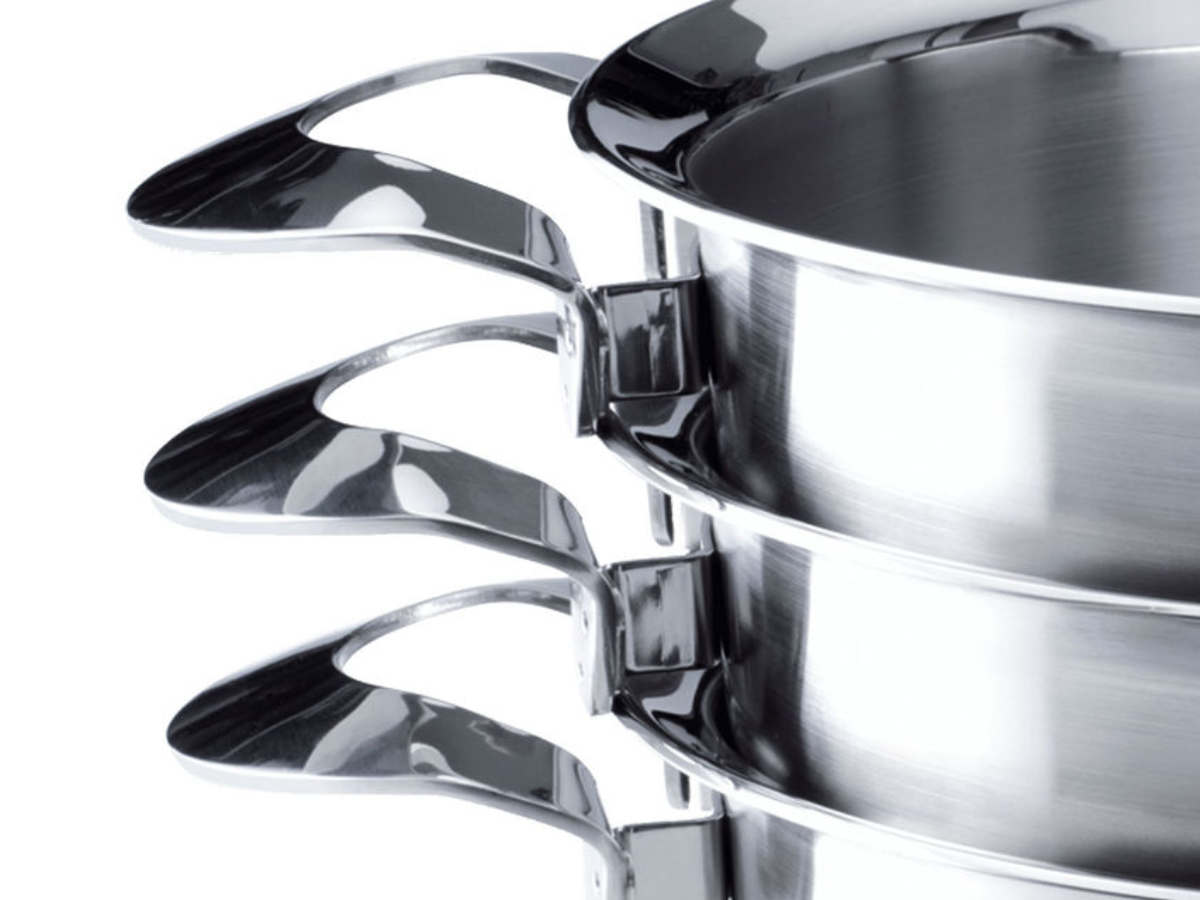 Four stacked Fissler stainless steel pots with polished sides and ergonomic handles. Precisely crafted. Made in Germany.