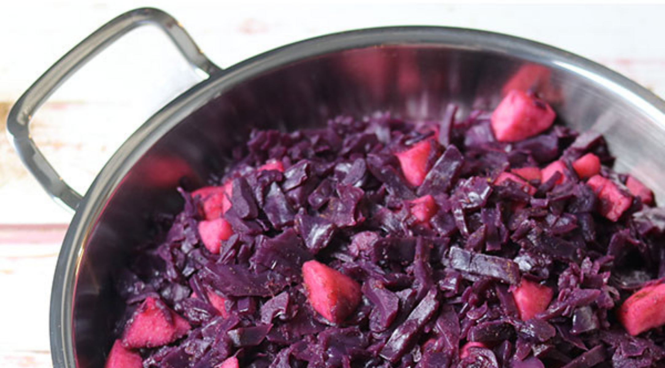 Ein Fissler-Edelstahltopf mit leuchtendem Rotkohl und Äpfeln ist ein Beispiel für hochwertige deutsche Handwerkskunst und zeitloses Design.