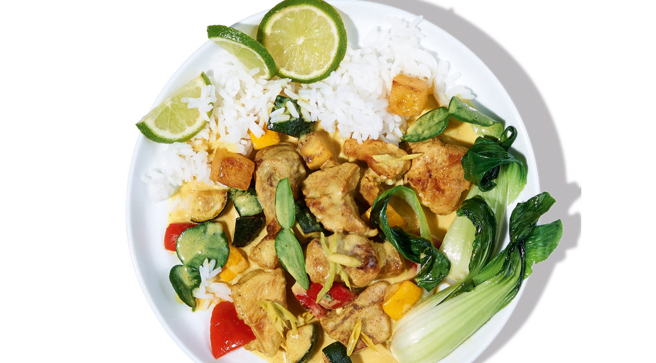 Ein farbenfrohes Gericht mit weißem Reis, buntem Gemüse, Bok Choy und goldenem Hühnercurry, zubereitet im hochwertigen Fissler-Kochgeschirr.