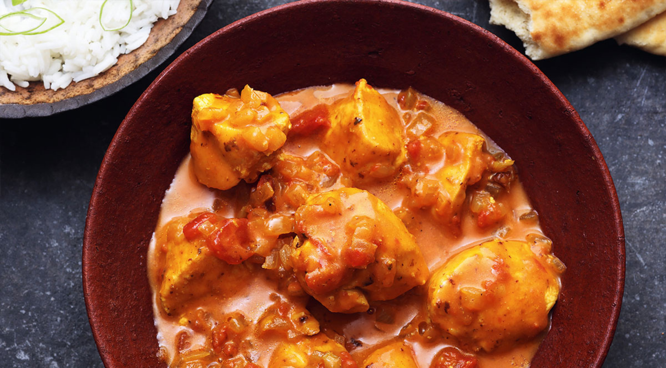Hähnchencurry, serviert in einer hochwertigen Fissler-Edelstahlschüssel, mit Reis und Naan an der Seite - ein Beweis für deutsche Designpräzision.