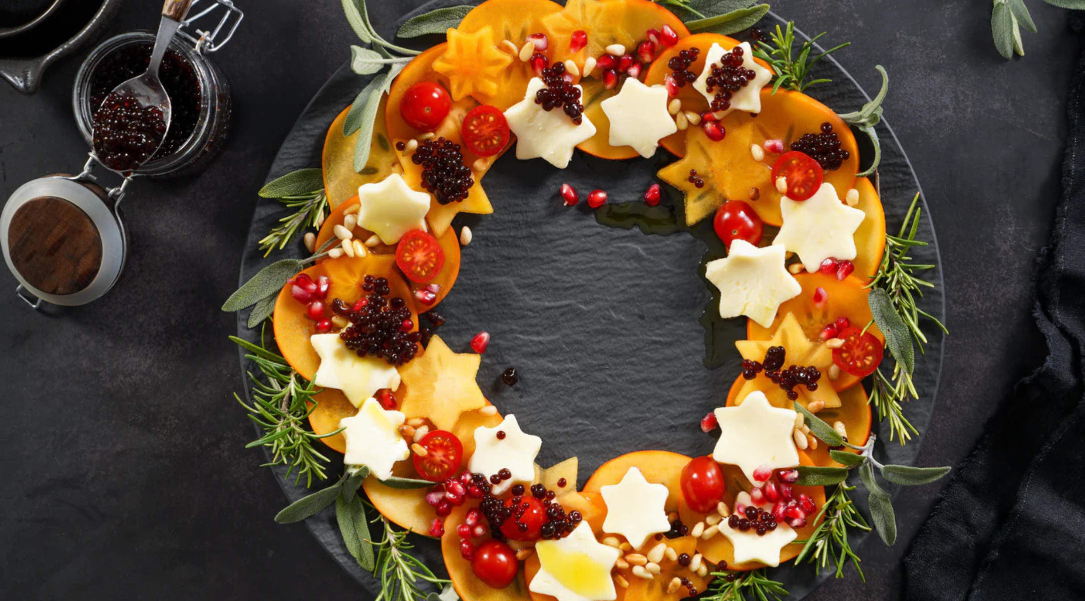 Festlicher Kranzsalat auf einem dunklen Teller, mit frischen Zutaten zubereitet - präzise plattiert, bereit für Fissler-Serviergeschirr.
