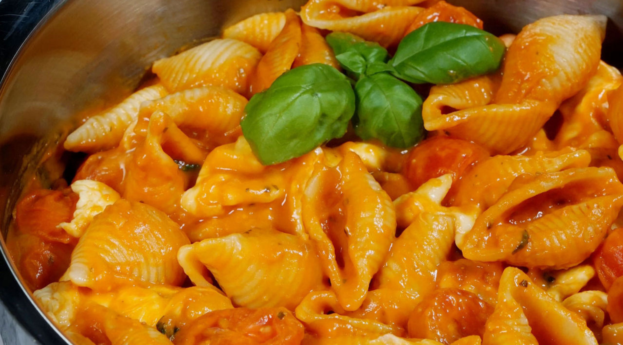 Nudelschalen in cremiger Tomatensauce mit geschmolzenem Käse und Basilikum, perfekt gekocht in einem Fissler-Edelstahltopf.