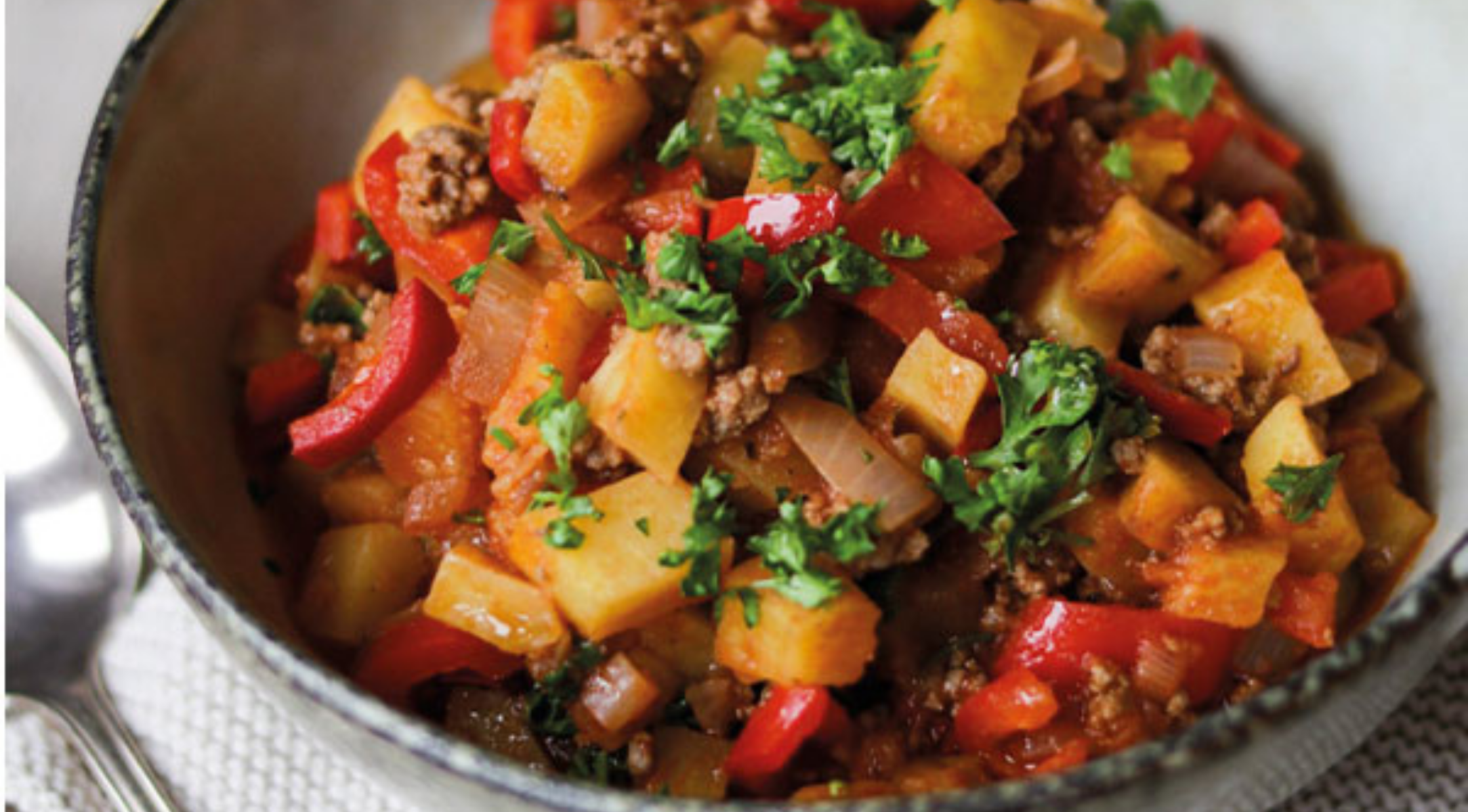 Kräftiges Haschisch mit Kartoffeln, Fleisch, Paprika und Petersilie, serviert in einer Schüssel - perfekt zubereitet mit Fissler Kochgeschirr.