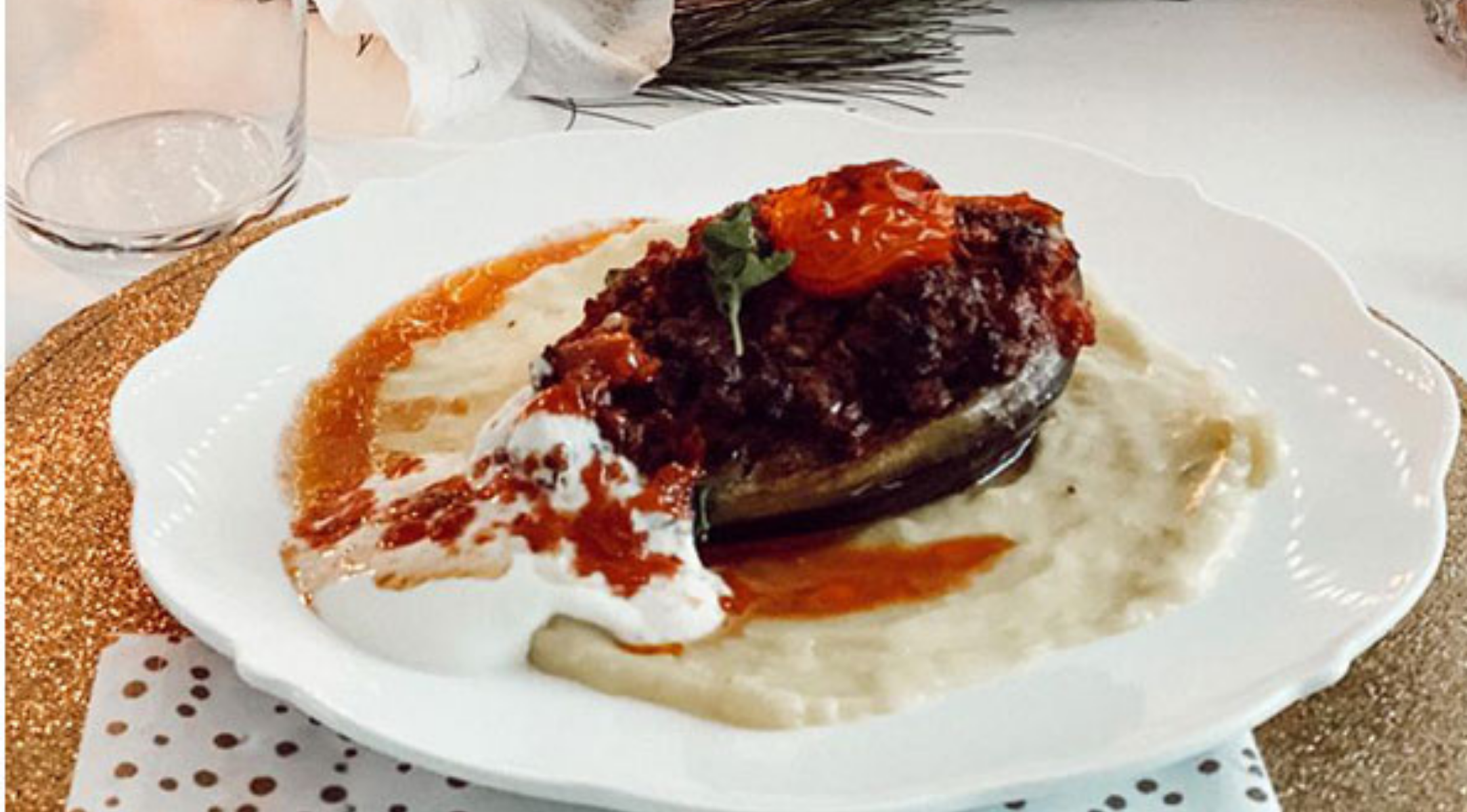 Gefüllte Aubergine mit Tomatensoße auf Püree, Joghurtbeilage, elegant serviert - perfekt gegart im Fissler-Topf.
