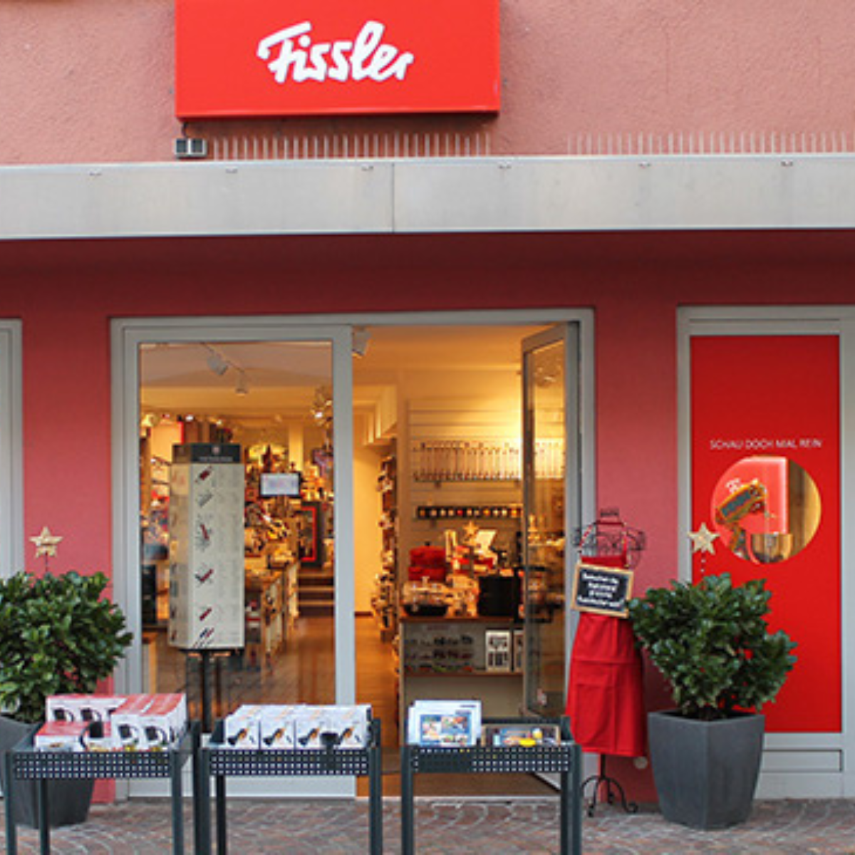 Das Fissler-Geschäft präsentiert hochwertiges, in Deutschland hergestelltes Kochgeschirr, mit rostfreien Töpfen und Pfannen, die im und vor dem Eingang ausgestellt sind.