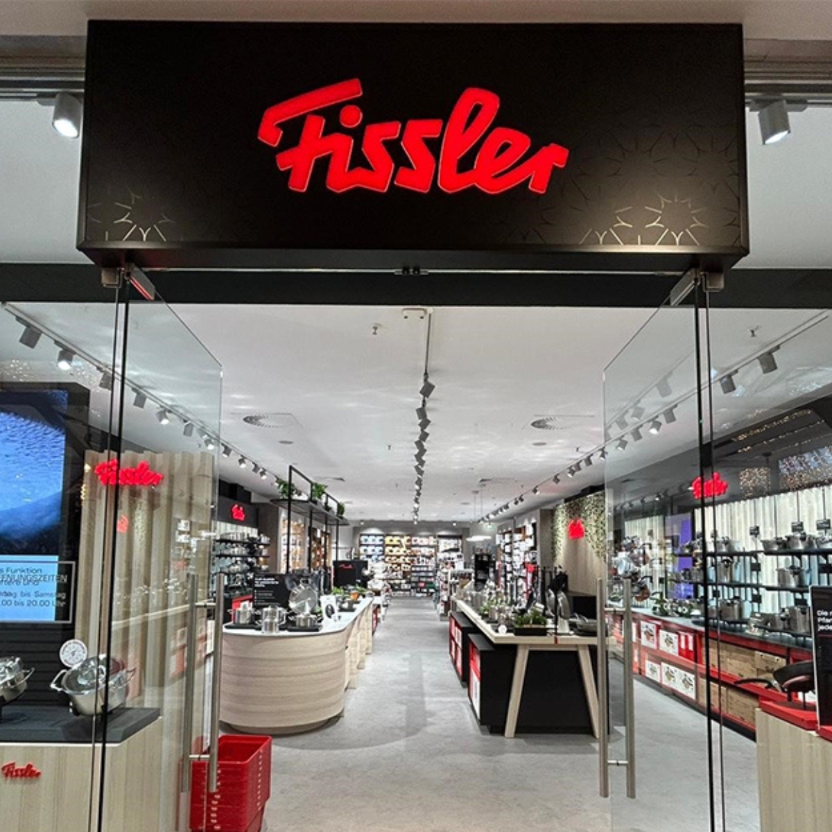 Das Innere des Fissler-Geschäfts mit Glastüren, moderner Beleuchtung und Auslagen mit hochwertigen Töpfen, Pfannen und Küchengeräten aus deutscher Produktion.
