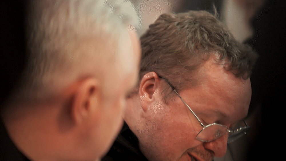 Two men, one with distinguished gray hair and the other with glasses and brown hair, sit side by side in a focused moment. The blurred background creates an intimate setting that reflects Fissler’s dedication to precision and craftsmanship. Their thoughtful expressions evoke the care put into every stainless steel pot, pan, or pressure cooker—timeless design at the heart of German kitchen innovation.