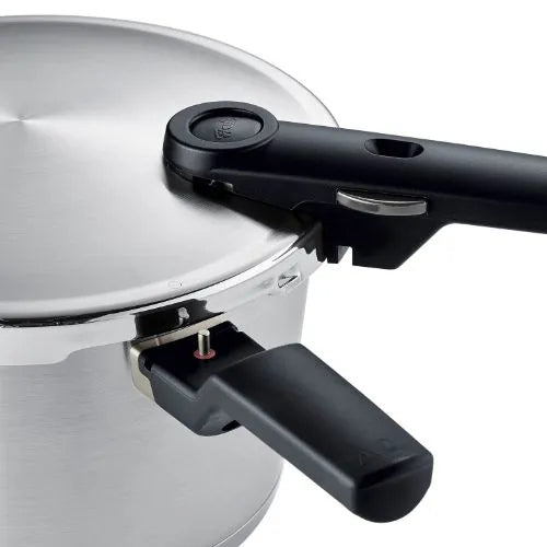 Nahaufnahme eines Fissler Schnellkochtopfs aus Edelstahl mit präzisionsgefertigtem Deckel und ergonomischen schwarzen Griffen.