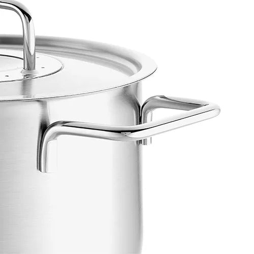 Nahaufnahme eines Fissler-Edelstahltopfs und -Deckels mit präziser deutscher Technik, robustem Griff und zeitlosem, reflektierendem Finish.
