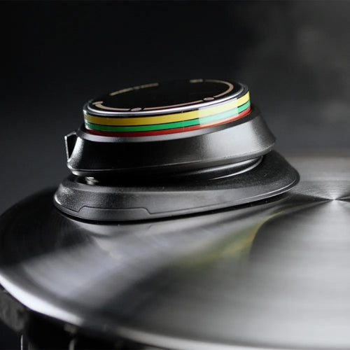 Detailansicht eines Fissler Schnellkochtopfdeckels mit Präzisionsdruckanzeige in grün, gelb, rot; hochwertige, reflektierende Stahlausführung.