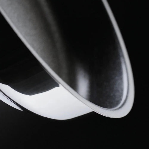 Nahaufnahme des gewölbten Randes und der polierten Oberfläche einer Fissler-Edelstahlpfanne, die deutsche Präzision und zeitloses Design demonstriert.