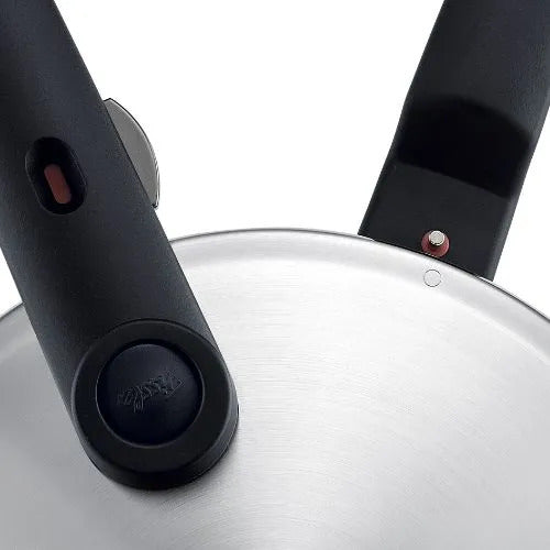 Nahaufnahme eines Fissler Schnellkochtopfdeckels aus Edelstahl mit ergonomischen schwarzen Griffen und roten Sicherheitsanzeigen auf weißem Hintergrund.